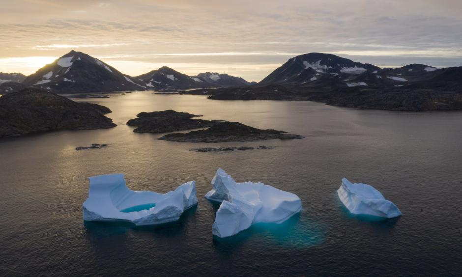 In this August 16, 2019 photo, large icebergs float away as the sun rises near Kulusuk, Greenland. Scientists are hard at work trying to understand the rapid melting of the ice. Credit: Felipe Dana, AP