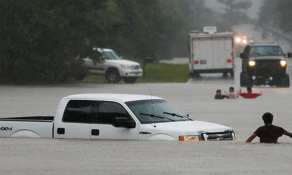 The three men in the foreground had to abandon their truck Friday after getting caught in rising flood waters in Magnolia, Tex. Photo: Michael Ciaglo, Houston Chronicle, via Associated Press