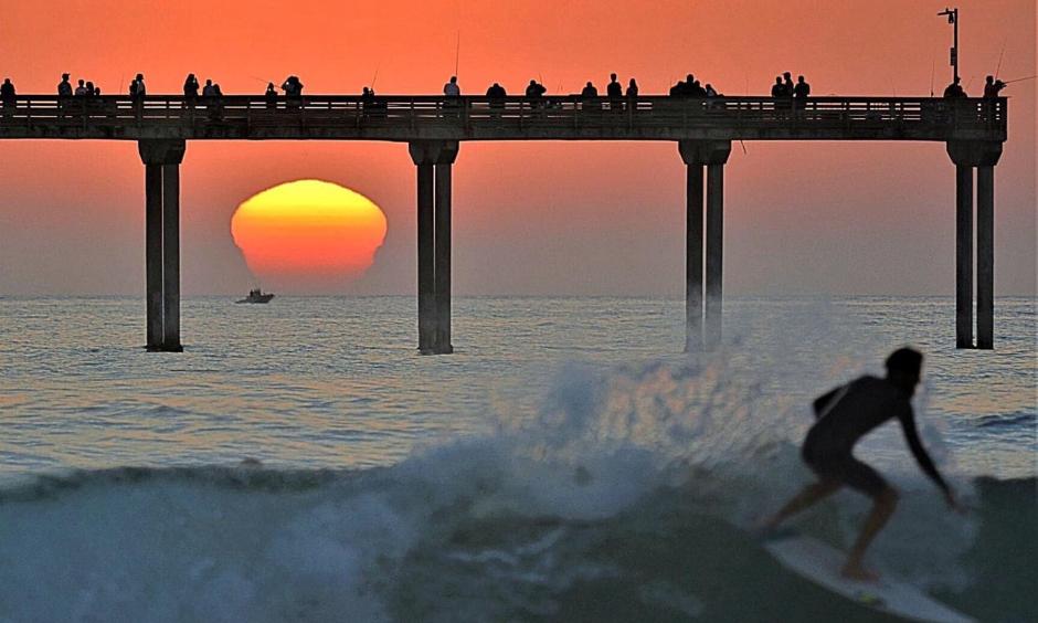 A surfer attempts to beat the heat in San Diego on Sunday. Credit: Jim Grant via Twitter