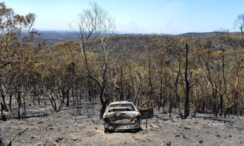 A charred car stands destroyed after a bushfire moved through the area near One Tree Hill in the Adelaide Hills. Photo: Yahoo News