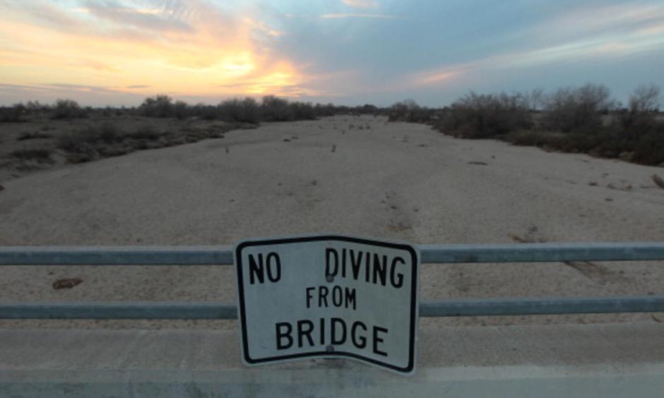 A sign from wetter times warns people not to dive from a bridge over the Kern River, which has been dried up by water diversion projects and little rain, on February 4, 2014 in Bakersfield, California. Photo: Associated Press
