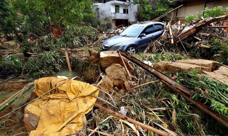 A car is buried in messes at Bandong Township after flooding in Minqing County, southeast China's Fujian Province, July 11, 2016. Photo: Zhang Guojun / Xinhua