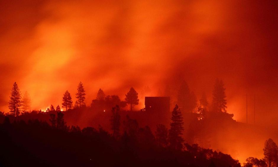 In this photo taken on November 10, 2018 Flames from the Camp fire burn near a home atop a ridge near Big Bend, California. Photo: Josh Edelson, AFP/Getty Images
