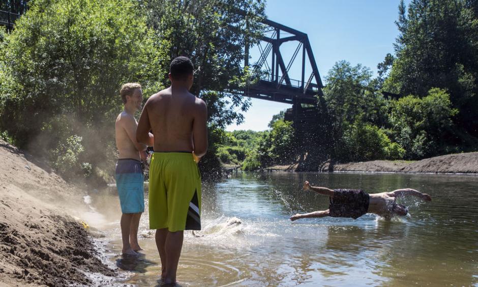 As his friends chat on the bank, Kamoni Taylor, 22, of Centralia, jumps into the Chehalis River with his dog, Bentley, 3, on Monday afternoon off of Highway 603 in Adna. Photo: Pete Caster, Chronline