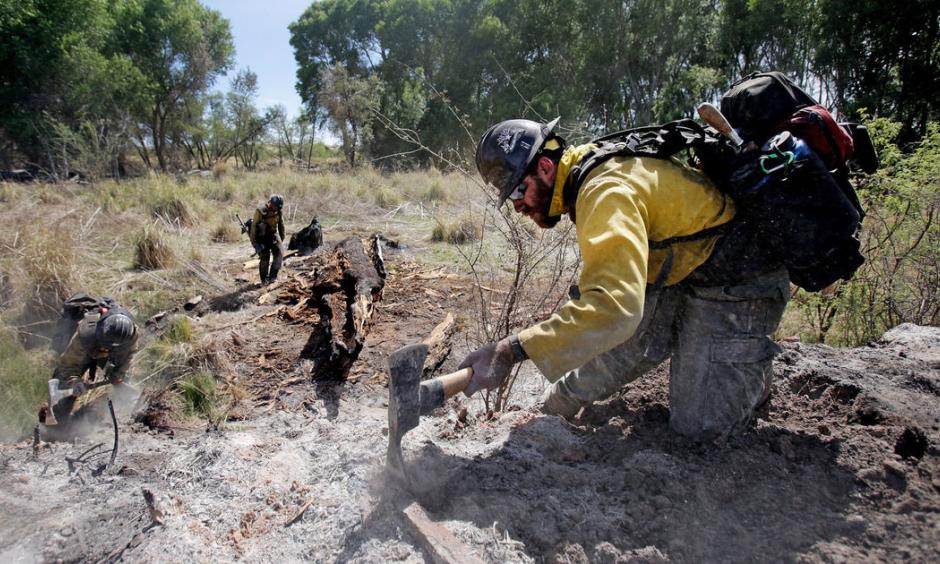 Mike Trubman, right, works with fellow Black Mesa Type-1 Interagency Hotshot Crew members Steve Daly, left, and Sean Hosier to mop up hot spots along Cienega Creek east of Empire Ranch while the Sawmill Fire burns on April 27, 2017, burning in Southeastern Arizona between Green Valley and J-6. Photo: Mike Christy, Arizona Daily Star