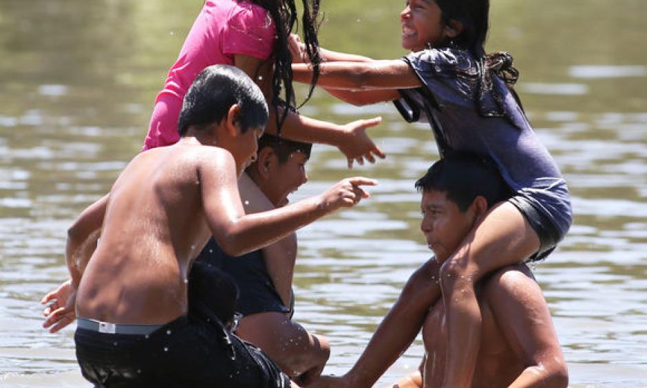 Members of the Amaya family square off with a "chicken fight" in the cool waters of Hart Park Lake Thursday. Photo: Felix Adamo, The Californian