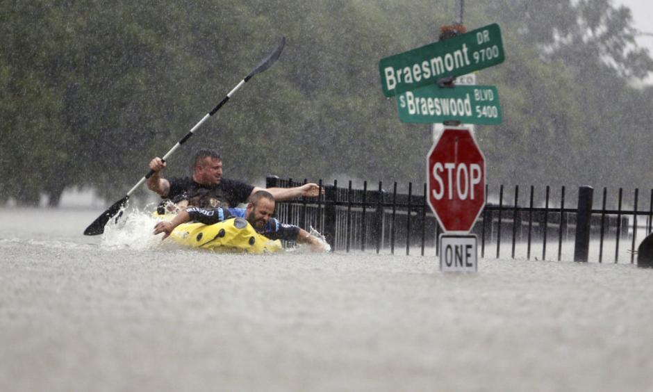 Two kayakers try to beat the current pushing them down an overflowing Brays Bayou from Tropical Storm Harvey in Houston, Texas, Sunday, Aug. 27, 2017. Photo: Mark Mulligan/Houston Chronicle via AP