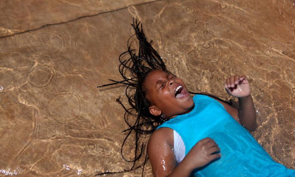 Trelynn Watkins, 10, laughs as she plays in the Julia Primrose Fountain. Credit: Genna Ord, The Gazette