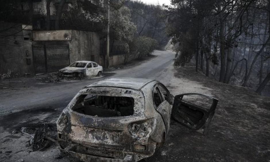 Burnt automobile line the streets following a wildfire east of Athens, on July 25. Credit: Yorgos Karahalis, Bloomberg