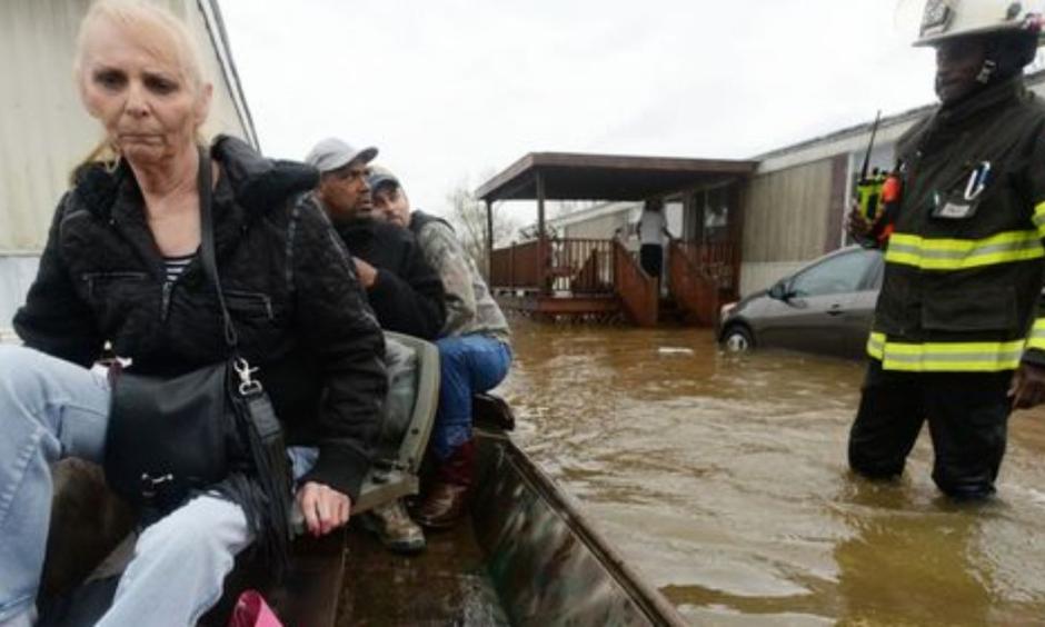 Marcie Traylor rides in a boat after being rescued from the Pecan Valley Mobile Home community that was flooded because of Wednesday rains. Bossier Firefighter Cameron LaCoure was out helping as well as neighbors who volunteered their boats for rescues. Photo: Henrietta Wildsmith/The Times