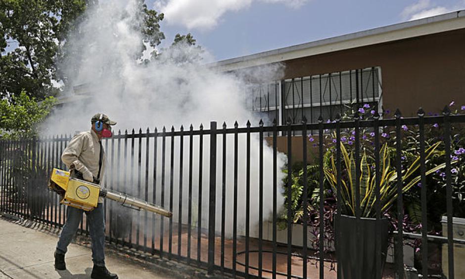 A Miami-Dade County mosquito control worker sprays around a home in the Wynwood area of Miami on Monday, Aug. 1, 2016. Photo: Alan Diaz
