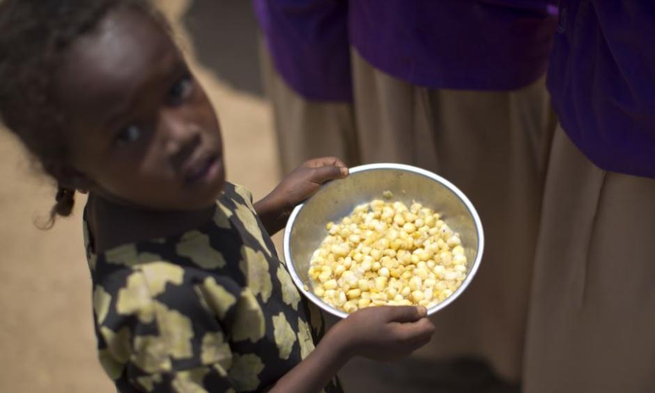 A child holds a bowl of food given out during a food distribution in the drought-affected village of Bandarero, near Moyale town on the Ethiopian border, in northern Kenya, March 3, 2017. Photo: Voice of America via AP