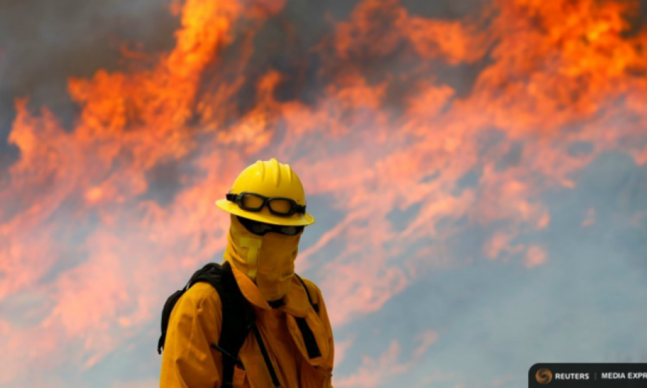 A firefighter from Chino Hills keeps watch on a wildfire as it burns near Potrero, Calif. Photo: Mike Blake, Reuters