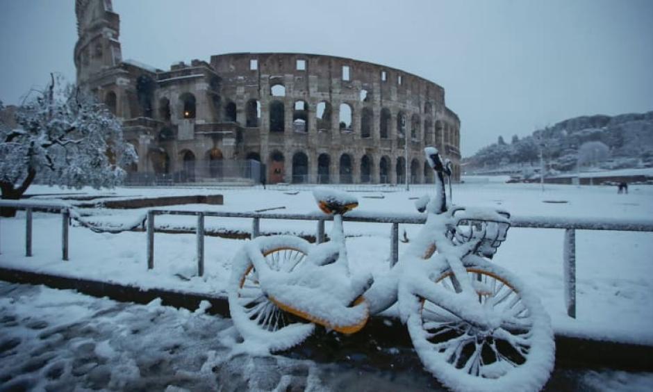 A bicycle is parked in front the ancient Colosseum during a snowfall in Rome. Photo: AP