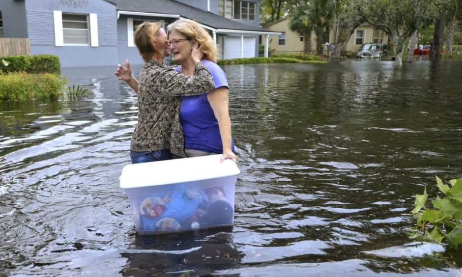 Charlotte Glaze gives Donna Lamb a teary hug as she floats out to some of belongings in teh floodwaters from the Ortega River in Jacksonville, Florida, Monday, Sept 11, 2017, after Hurricane Irma passed through the area. Photo: Dede Smith, The Florida Times-Union via AP