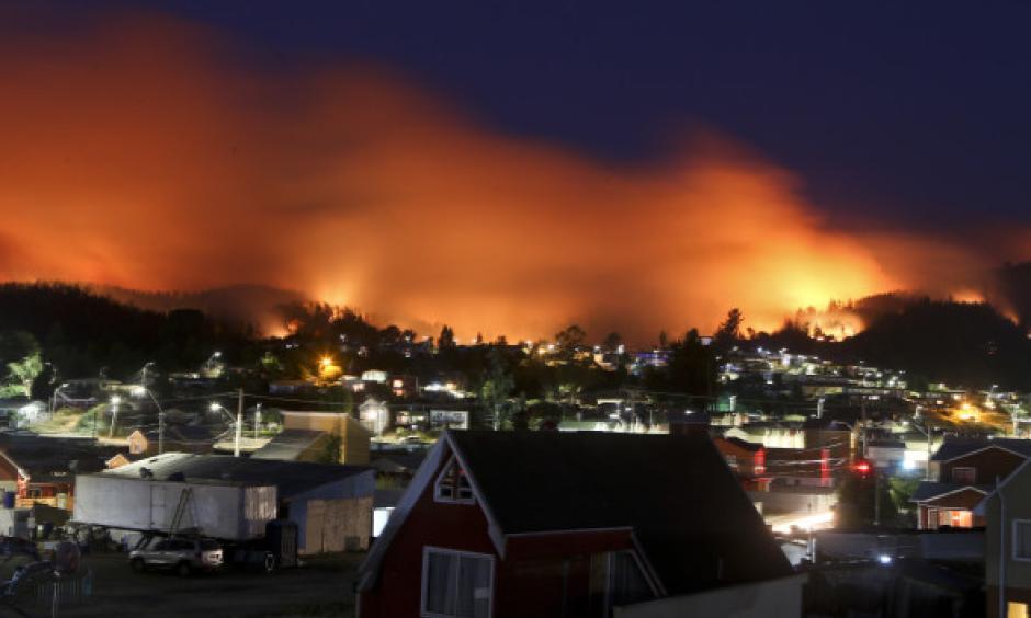 A wildfire approaches Chile's Dichato community, Monday, Jan. 30, 2017, where firefighters are working to keep the flames away from the estimated 800 homes. Families continue to be evacuated as firefighters battle the fires that are consuming a part of southern Chile. Photo: Esteban Felix, AP