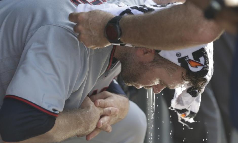 Minnesota Twins' Brian Dozier has a cold wet towel applied to his head during the seventh inning of a baseball game Chicago Cubs Saturday, June 30, 2018, in Chicago. Temperatures at Wrigley Field climbed into the mid 90's with a heat index over 100 degrees. Credit: Charles Rex Arbogast, AP