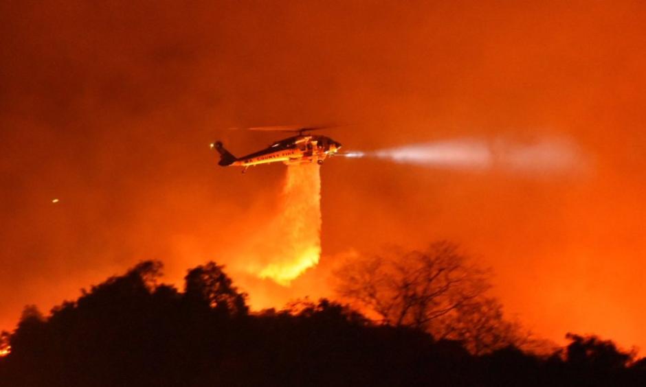 A Los Angeles County Firehawk copter makes a water drop on flames off CA Highway 154 north of Foothill Road. Credit: Mike Eliason / Santa Barbara County Fire