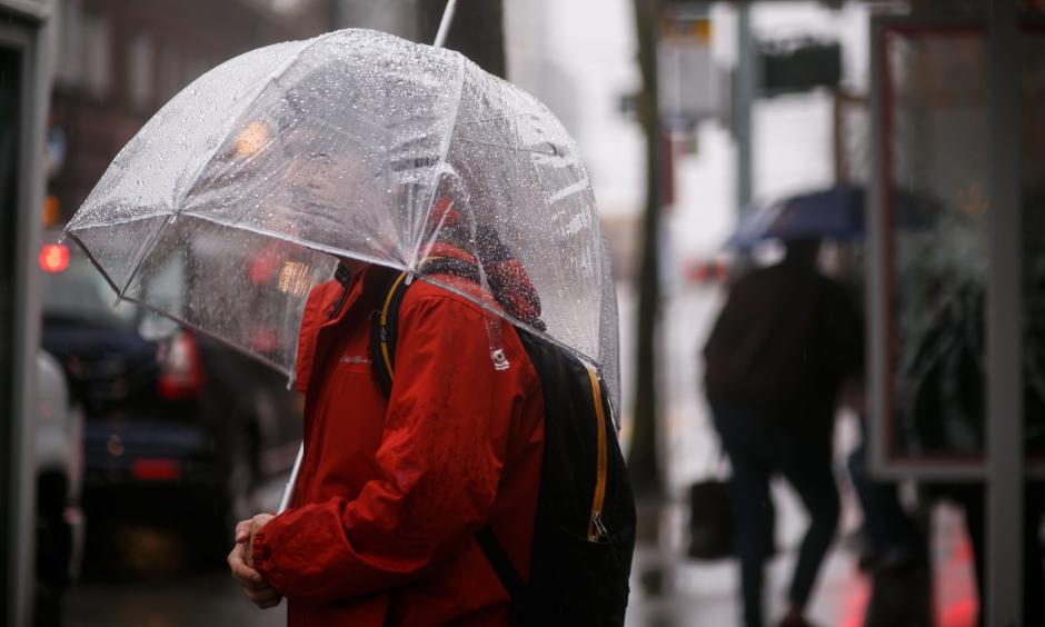 Jeremy Kahn waits for the bus in the rain in West Seattle last month. Photo: Erika Schultz, The Seattle Times