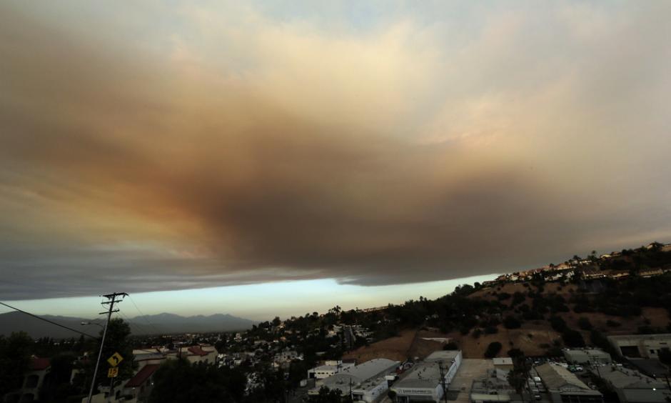 Smoke from a nearby wildfire looms over Los Angeles on Friday, viewed from Monterey Park, Calif. Photo: Nick Ut/AP