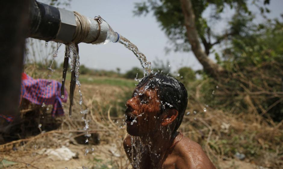 An Indian man takes bath under the tap of a water tanker on a hot day in Ahmadabad, India, Thursday, May 21, 2015. Photo: AP