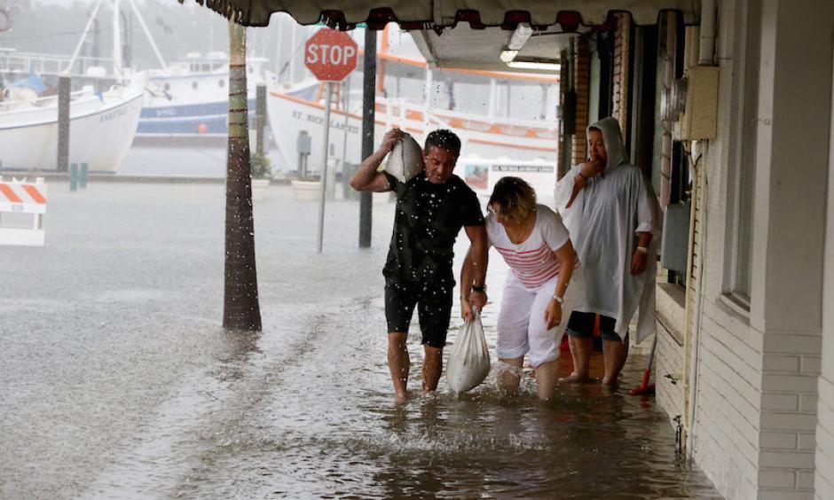 Angelo Memiakis, left, and Kelly Spiliotis work to deliver sandbags to the door jams of businesses along flooded Athens Street on Monday, June 6, 2016, in Tarpon Springs, FL, as Tropical Storm Colin barreled up the west coast of Florida. Photo: Douglas R. Clifford/The Tampa Bay Times via AP