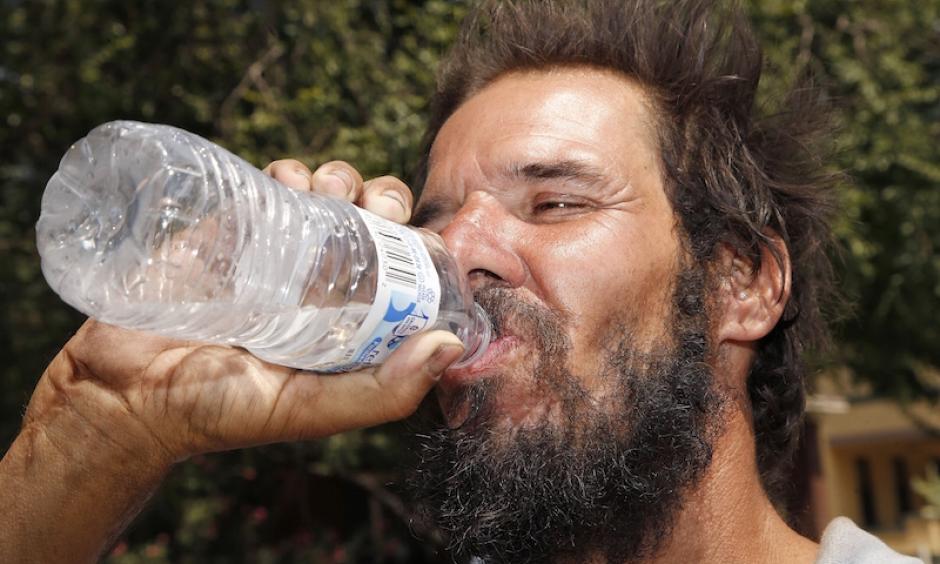 Michael Martinez drinks a bottle of water at a Salvation Army hydration station in an effort to beat rising temperatures in Phoenix on Monday, July 20, 2016. Phoenix set daily record highs of 118°F on Sunday and 116°F on Monday, which were the earliest readings above 115°F in city history. Photo: Ross D. Franklin, AP