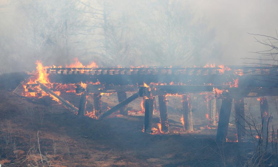 A old train trestle bridge burns near Lake City, KS, on Wednesday, March 23, 2016. The bridge was set afire by a large grass fire burning in Barber County, KS. Lake City is about 15 miles northwest of Medicine Lodge, where at least two homes were destroyed by fire. Photo: Travis Morisse, The Hutchinson News via AP