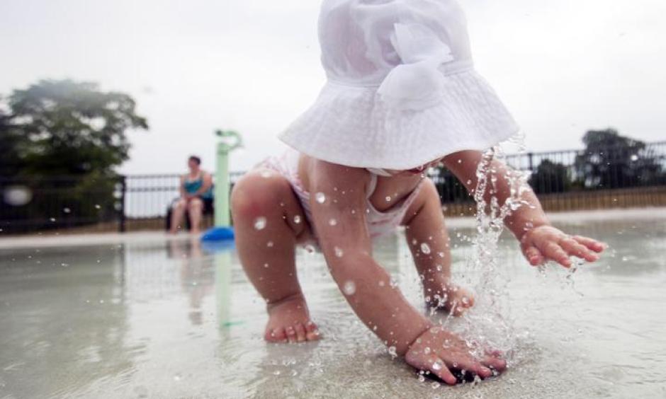 Ella Roberts, 1, of Saginaw Township uses her hands Wednesday, July 6, to cover a water spout at Celebration Square Splash Park in Saginaw. Photo: Josie Norris, The Saginaw News via AP