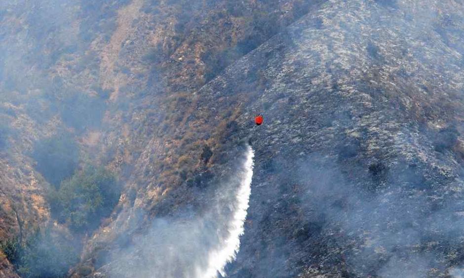 A helicopter makes a water drop on the Soberanes Fire as it burns on the west slope of Mount Manuel in Pfeiffer Big Sur State Park on Tuesday. Photo: Vern Fisher / Monterey Herald