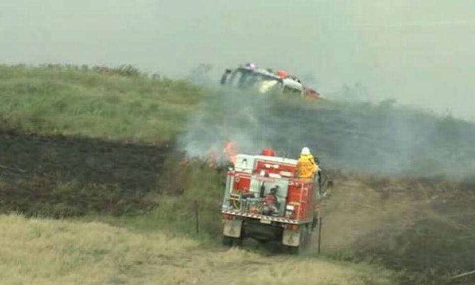 Crews work to contain a grass fire near the Hume Highway, Goulburn. (Image: 9News)