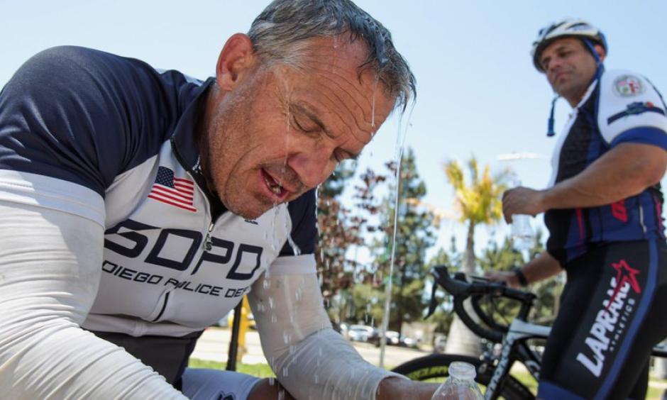 Water from his water bottle drains off cyclist and race coordinator Darrell McPherren, a retired San Diego Police sergeant, as he and Los Angeles Police officer Andy Vergala try to cool off with the temperatures at 102 degrees after competing in the bike race portion of the United States Police and Fire Championships, which going on all this week in San Diego County, in Escondido on Sunday. Photo: Hayne Palmour IV / San Diego Union-Tribune