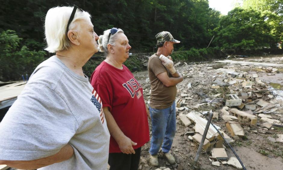 Emma Allen, center, and James Allen look at the remnants of their home after flooding damage with Pauline Stanley in Clendenin, W.Va., on Sunday. Photo: Marcus Constantino / Reuters