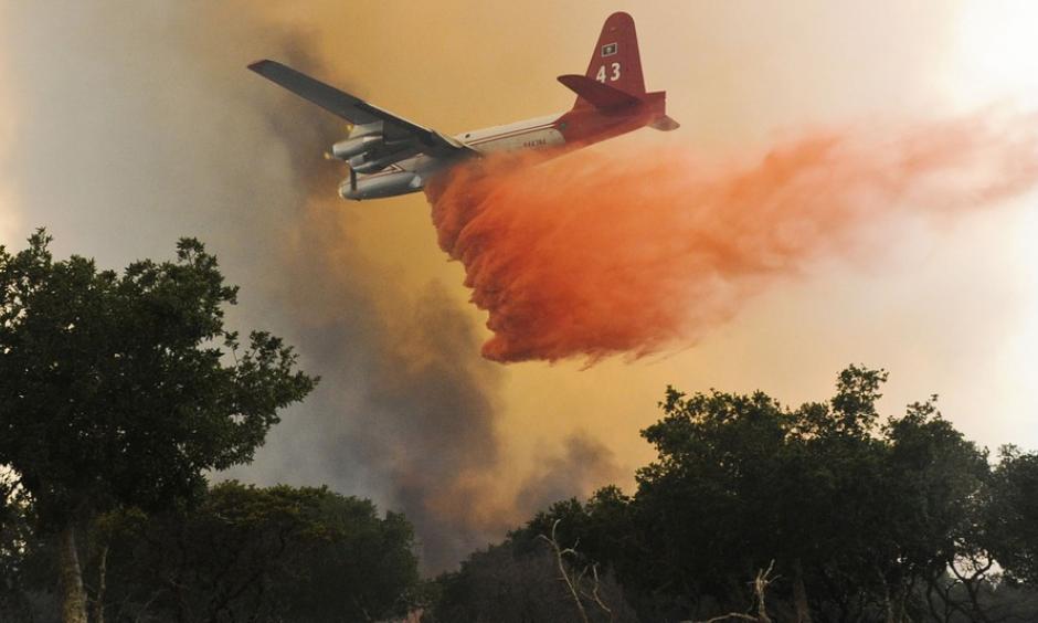 A plane drops a load of retardant on a wildfire north of Lompoc, California, Monday, June 29, 2015. Photo: Associated Press