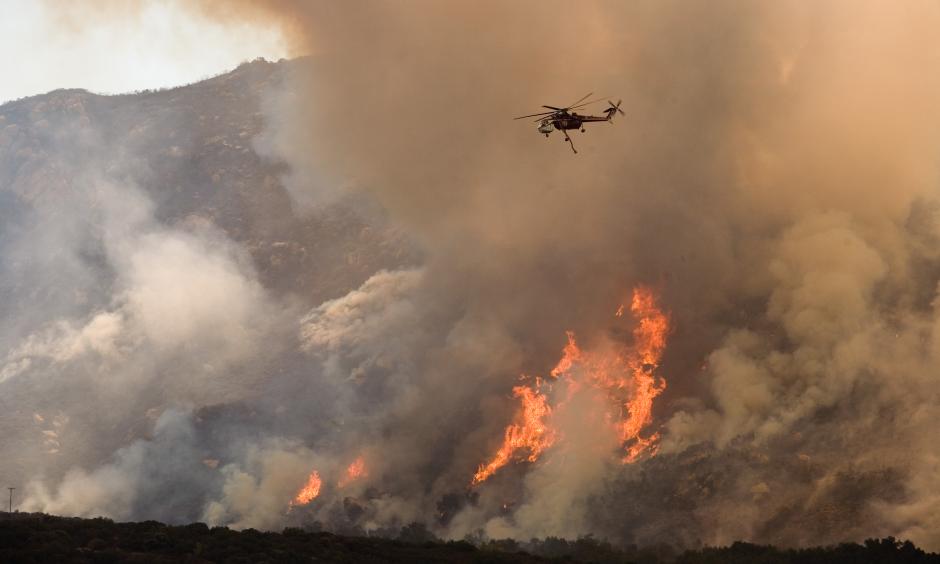 A helicopter drops water on the wildfire in California. Photo: FEMA