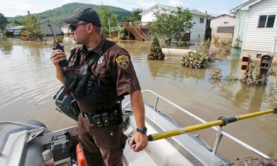 Lt. Dennis Feazell, of the West Virginia Department of Natural Resources, contacts his command center as he and a co-worker search flooded homes in Rainelle, W. Va., Saturday, June 25, 2016. Photo: AP