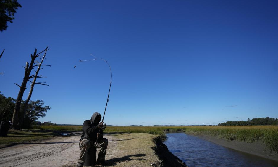 Gullah Geechee fisherman Ricky Wright casts his line as he fishes for bass in a marsh waterway with eroded banks on St. Helena Island, S.C., Sunday, Oct. 31, 2021. (AP Photo/Rebecca Blackwell)