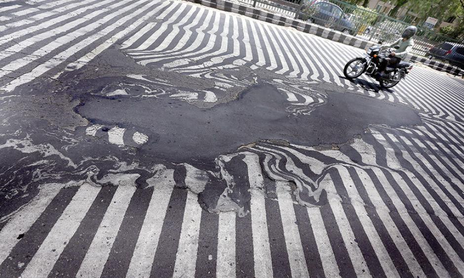 Road markings appear distorted as the asphalt starts to melt due to the high temperature in New Delhi. Photo: EPA/HARISH TYAGI