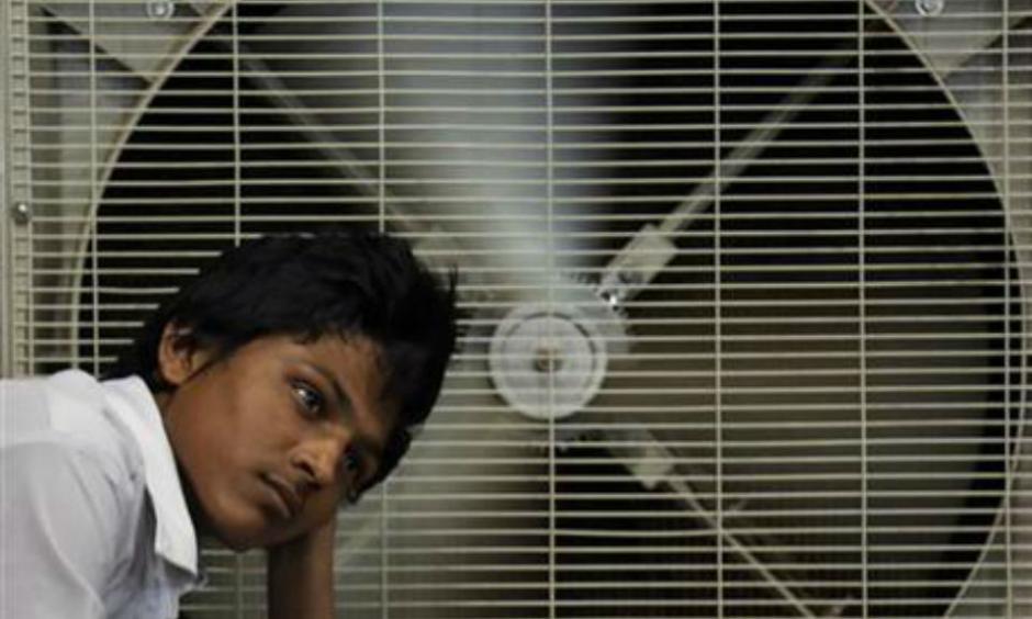In this May 31, 2015 file photo, an Indian man rests in front of an air cooler to cool. Photo: AP