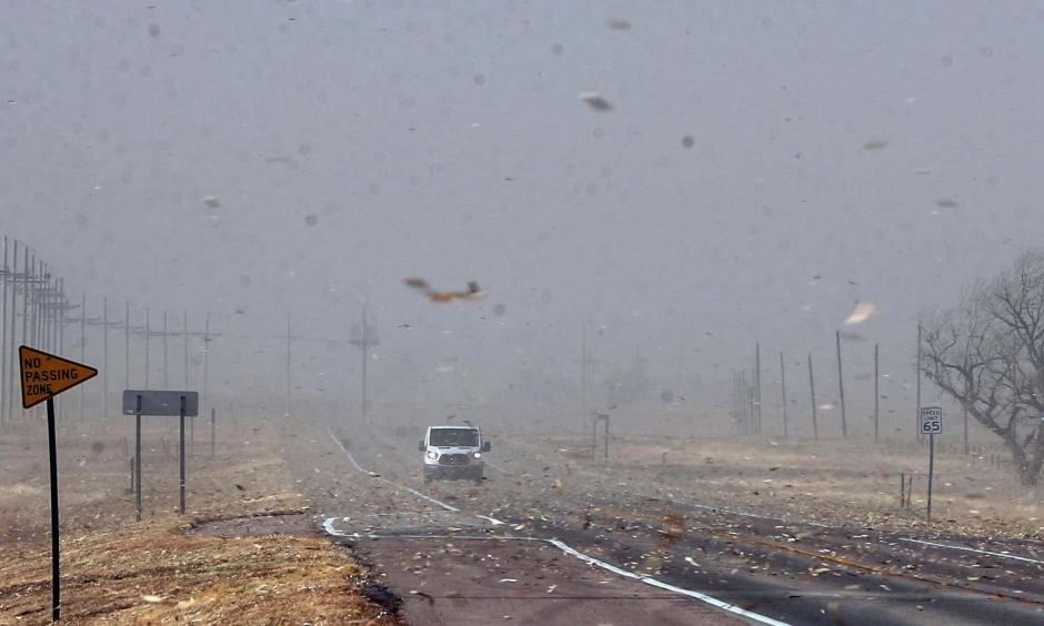 Debris from nearby farm fields swirls around on Highway 400 between Mullinville, Kansas, and Dodge City. (Credit: Travis Heying/The Wichita Eagle (AP))