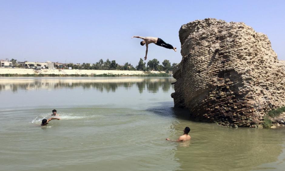 Iraqis jump off the ruins of an old building into the Tigris River to beat the heat in Baghdad on Aug. 1. The temperature in Baghdad reached 117 degrees. Photo: Ali Abdul Hassan/AP