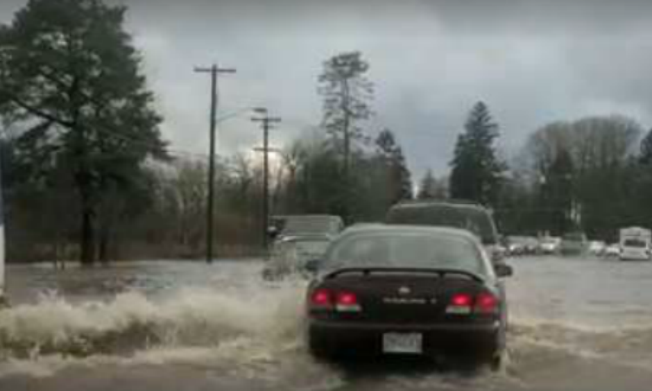 Drivers cautiously proceed through Johnson Creek floodwaters on SE Foster Road near 111th Avenue. Heavy rain caused flooding and landslides in the Portland area on Monday, December 7, 2015.