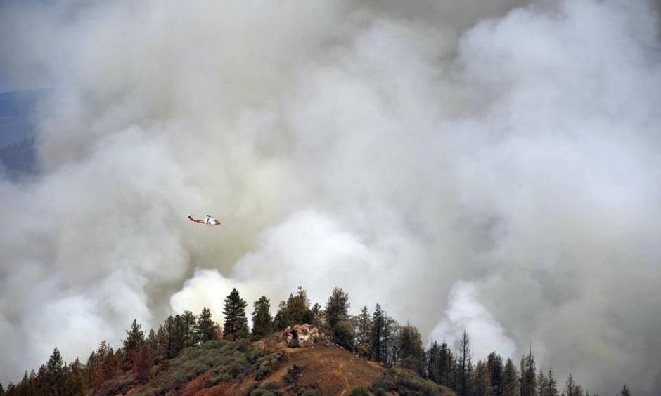 A United States Forest Service Cobra helicopter flies over the burn-out operation along McKenzie Ridge Saturday, September 19, 2015 near Kings Canyon National Park, Calif. ERIC PAUL ZAMORA
