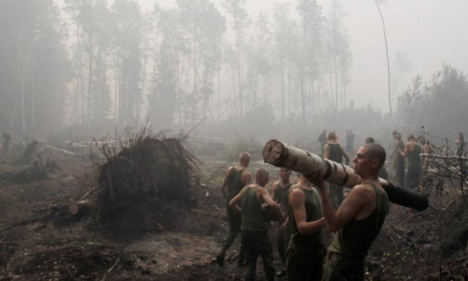 Russian service members haul away trees felled to hold wildfires at bay outside the town of Lukhovitsy on August 6. Photo: Denis Sinyakov, Reuters