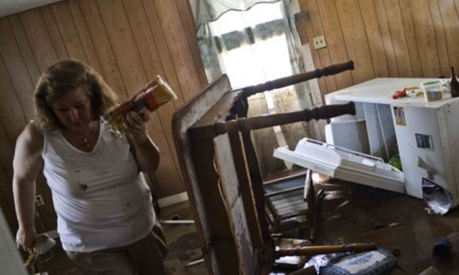 Theresa Havers helps clean out the kitchen of her son's home after flooding in Rainelle, W.Va., on June 26, 2016. Photo: Christian Tyler Randolph, Charleston Gazette-Mail, via AP