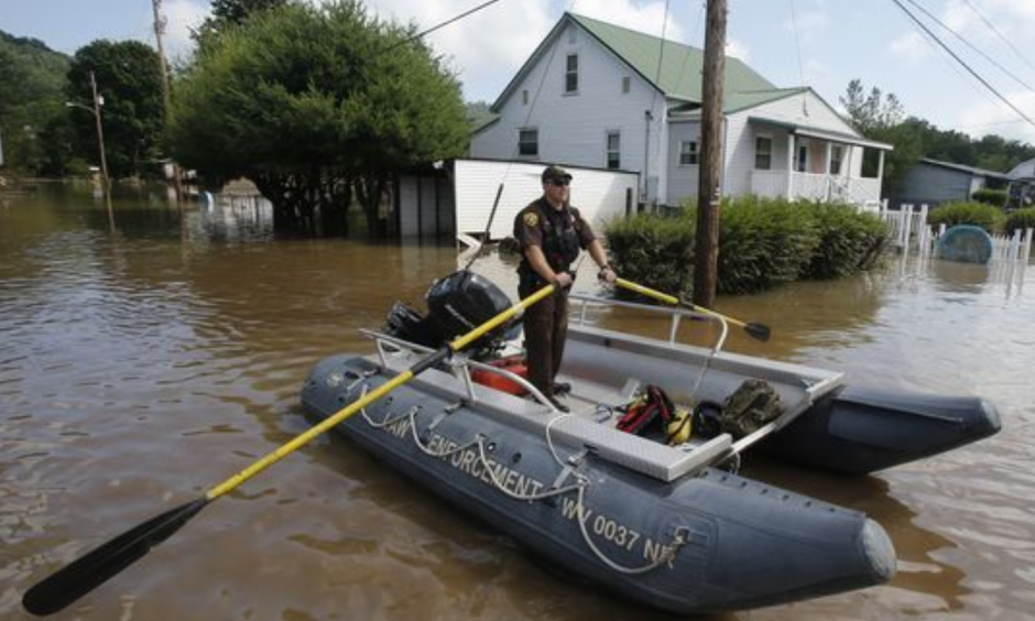 Lt. Dennis Feazell, of the West Virginia Department of Natural Resources, rows his boat as he and a co-worker search flooded homes in Rainelle, W. Va. on June 25, 2016. About 32,000 West Virginia homes and businesses remain without power Saturday after severe flooding hit the state. The West Virginia Division of Homeland Security and Emergency Management also said that more than 60 secondary roads in the state were closed. Photo: Steve Helber, AP