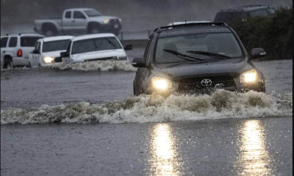 Car drives through flooded water