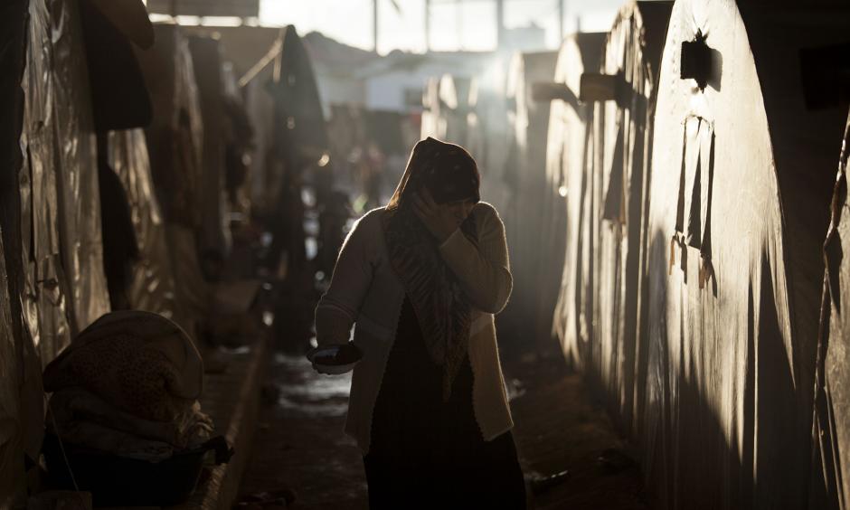 A Syrian refugee woman is seen between a line of tents in a refugee camp near Azaz, north of Aleppo province, Syria. Photo: Manu Brabo, AP