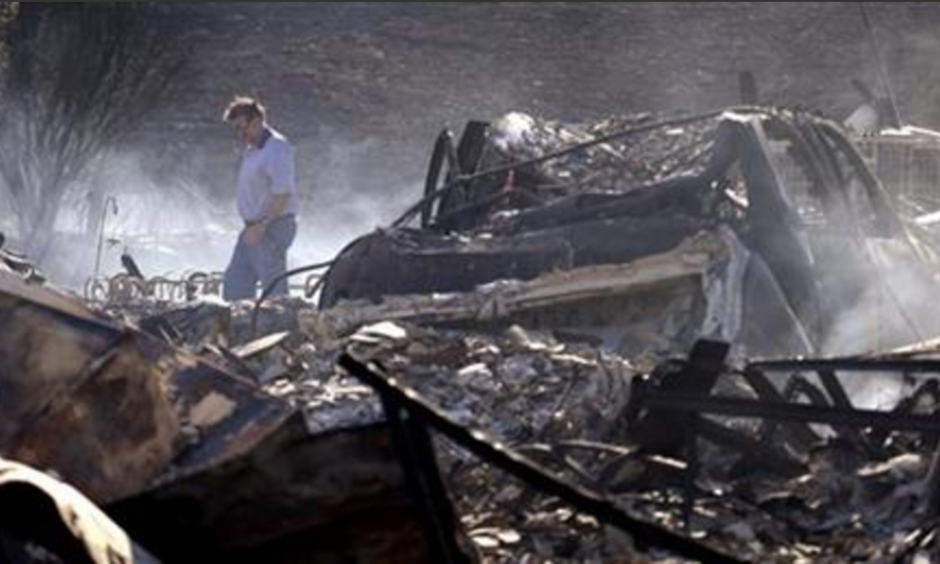 Vern Smith walks through the rubble of his still smoldering home on June 29, 2015, one of some two dozen destroyed in a wildfire the night before, in Wenatchee, Wash. Photo: Elaine Thompson, AP