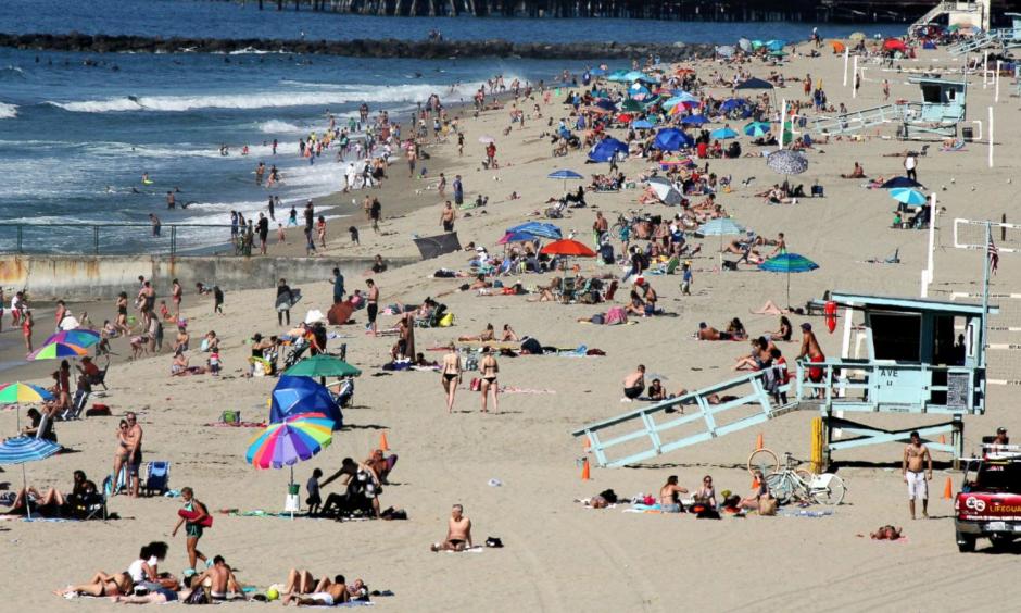 In this Feb. 15, 2016, file photo swimmers and sunbathers gather at Redondo Beach, Calif. El Nino has so far left much of drought-stricken California in the dust, delivering a few quick storms but not yet bringing the legendary rain previously linked to the periodic ocean-warming phenomenon. Image: John Antczak, AP Photo